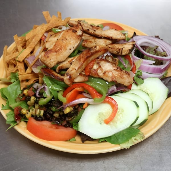 Grilled chicken salad with tortilla strips, bell peppers, red onions, cucumbers, and black bean corn salsa.